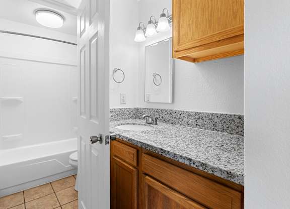 A bathroom with a white door and a marble counter top.at East Wind, Oregon