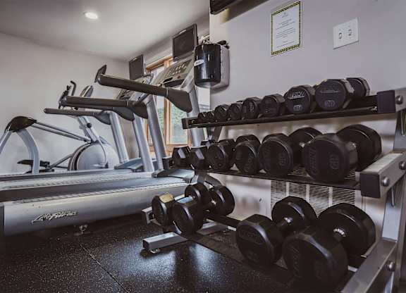 A gym with a treadmill, dumbbells and a certificate on the wall. at Oak Park City, Illinois