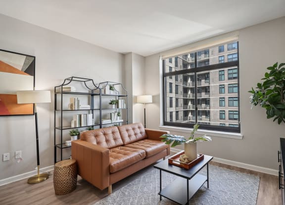 a living room with a brown couch and a large window