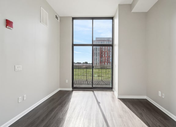 an empty living room with a door to a balcony