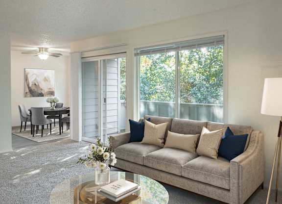 A living room with a grey couch, a coffee table, and a painting on the wall.