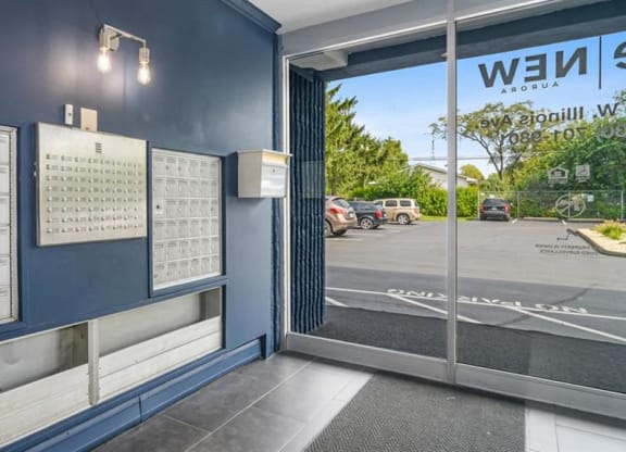 the lobby of a building with a wall of calendars and a door at ReNew Aurora, Aurora, IL, 60506