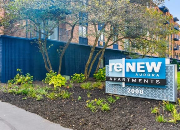 a blue building with a sign for new apartments at ReNew Aurora, Aurora, IL