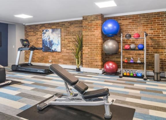 a home gym with a brick wall and exercise equipment at ReNew Aurora, Aurora, Illinois