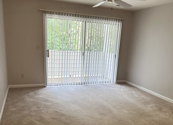 an empty room with a sliding glass door and a ceiling fan at Woodgate, Charlottesville, Virginia