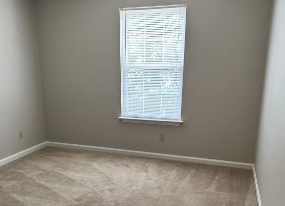 a bedroom with a large window and a carpeted floor at Woodgate, Virginia