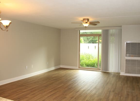 an empty living room with a ceiling fan and a windowat Renew Worcester, Massachusetts, 01602