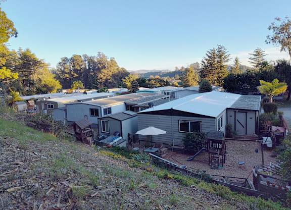 A group of houses are surrounded by trees and grass at Salinas Sunset Apartments, Salinas, CA, 93907