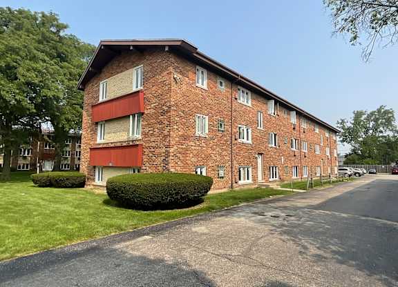A red brick apartment building with a green lawn in front.at The Countryside, Illinois, 60525?