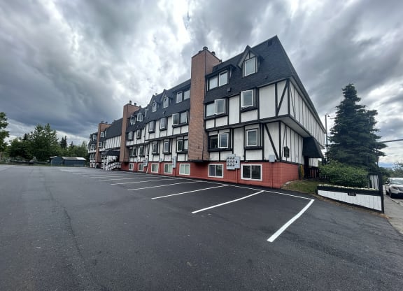 a large white and red building with a cloudy sky in the background at Kings Court, Anchorage, AK 99501 ?