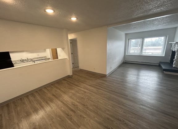 an empty living room with a kitchen and a window at Kings Court, Anchorage, AK ?