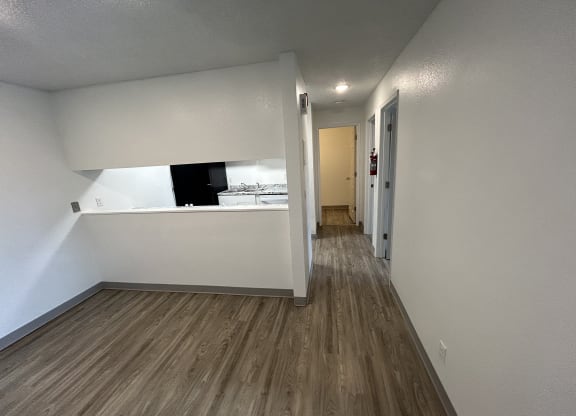 an empty living room with white walls and wood flooring at Kings Court, Alaska ?