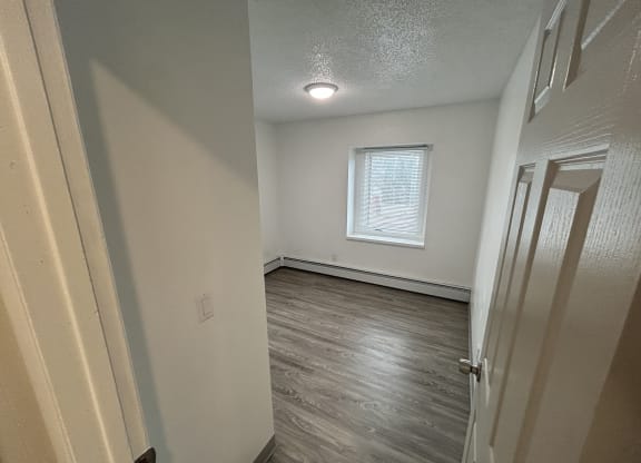 an empty room with wood floors and a window at Kings Court, Alaska ?