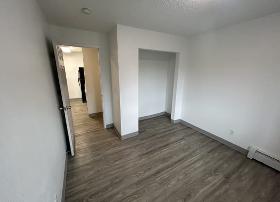 a bedroom and hallway with white walls and wood flooring at Kings Court, Anchorage, AK 99501 ?