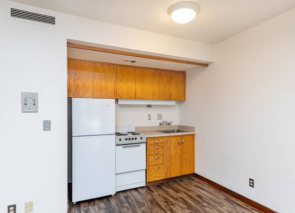 Kitchen with wooden cabinets and a white refrigerator at Julie Ann, Portland, 97215