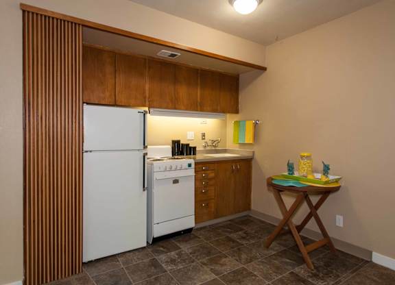 Bright Kitchen with a white refrigerator, wooden cabinets, and a table at Julie Ann, Portland, OR, Oregon