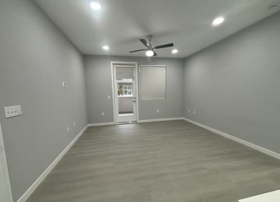 living room with a ceiling fan and a door