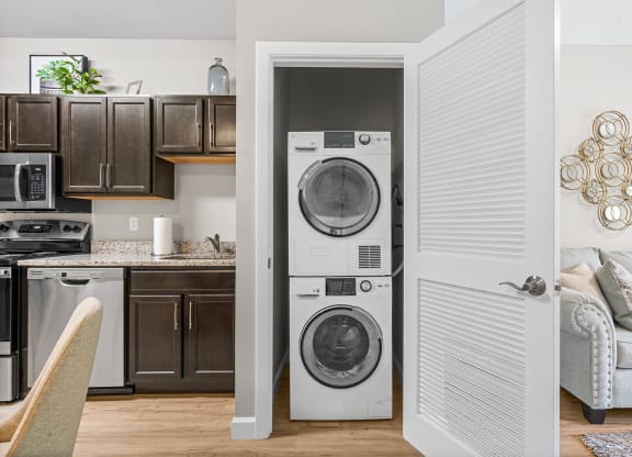 a living room and kitchen with a washing machine and a washer and dryer in it at Lofts at 335, Stratford, 06615