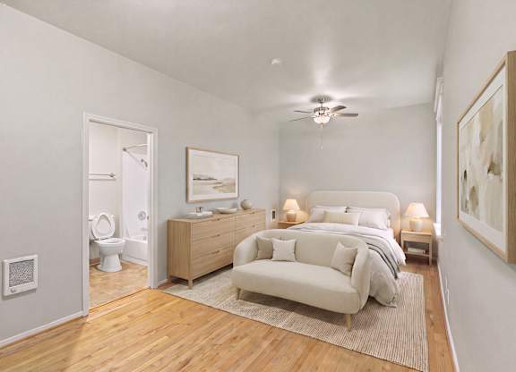 A bedroom with a bed, nightstand, and a couch.