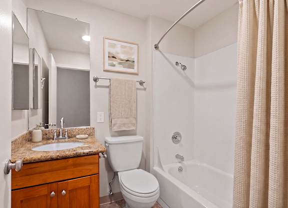 A bathroom with a toilet, sink, and bathtub.