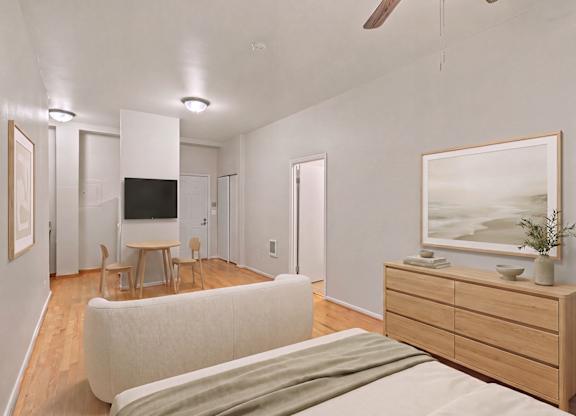 A living room with a white couch and a wooden cabinet.
