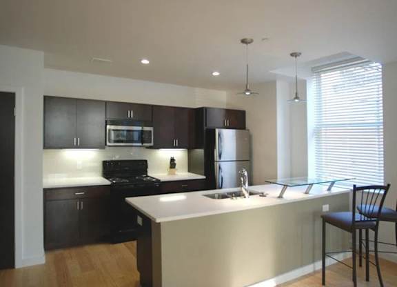 A kitchen with a black stove top oven and a black refrigerator.