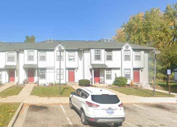 a white car parked in front of an apartment complex  at Mason Street Townhomes, Michigan, 49505