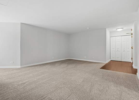 A room with a carpeted floor and white walls.