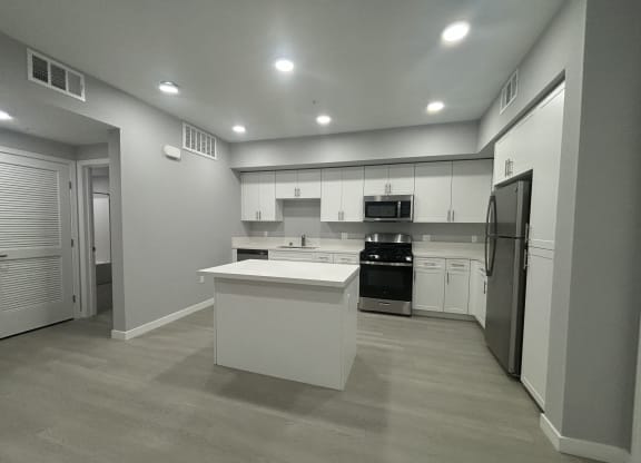 a kitchen with white cabinets and stainless steel appliances