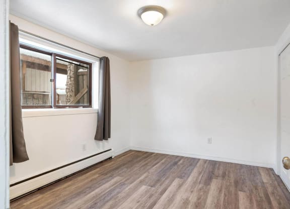 a bedroom with hardwood floors and white walls  at ReNew End Street, Alaska
