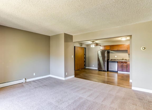 an empty living room with a kitchen in the background  at ReNew at Neill Lake, Eden Prairie, Minnesota