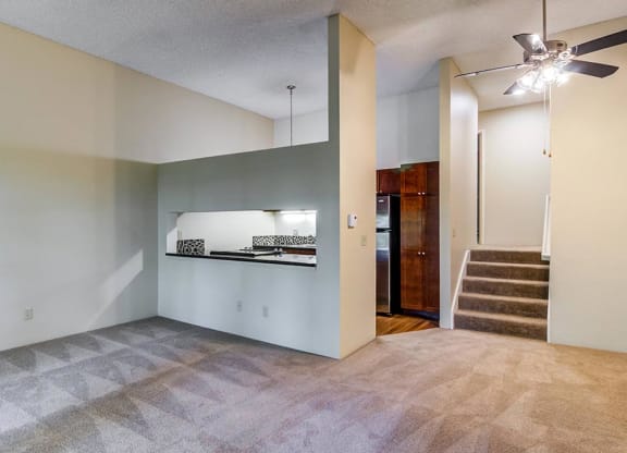 an empty living room with a ceiling fan at The Bluffs at Mountain Park, Lake Oswego, OR