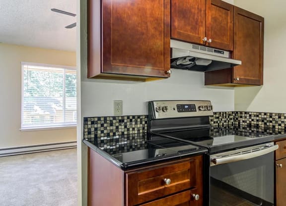a kitchen with a stove top oven next to a window at The Bluffs at Mountain Park, Lake Oswego, OR