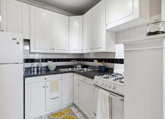 a white kitchen with white appliances and white cabinets at The Bryant at Oak Park I & II, Illinois