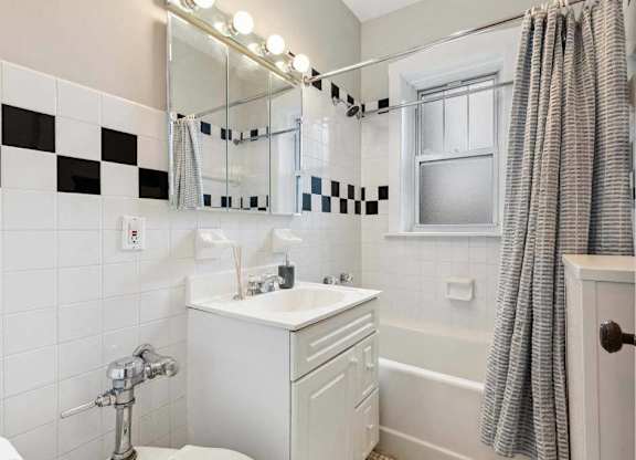 a bathroom with a sink and a mirror and a shower at The Bryant at Oak Park I & II, Illinois