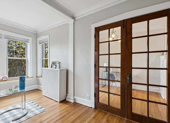 a living room with a wooden door and a window at The Bryant at Oak Park I & II, Oak Park, IL 60302
