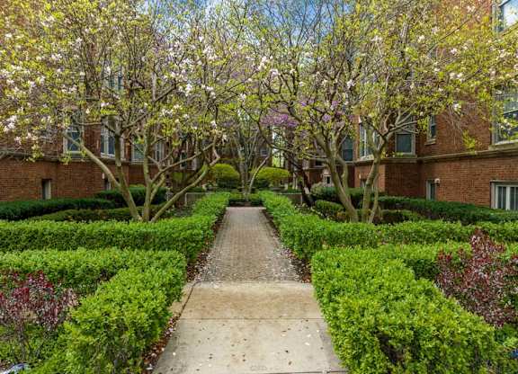a sidewalk in front of a building with trees and hedges at The Bryant at Oak Park I & II, Oak Park, IL 60302