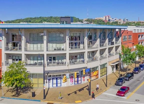 a large building with a blue roof on a city street at Flats at Southside, Pittsburgh, 15203