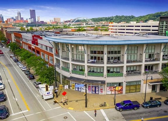 a large building with a blue roof on a city street at Flats at Southside, Pittsburgh Pennsylvania