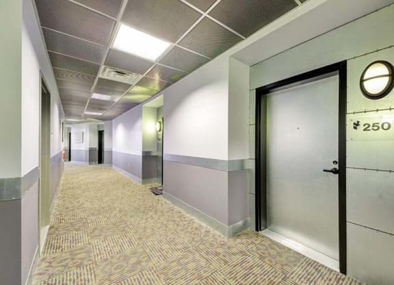 a hallway with a door and a clock on the wall at Flats at Southside, Pittsburgh, PA