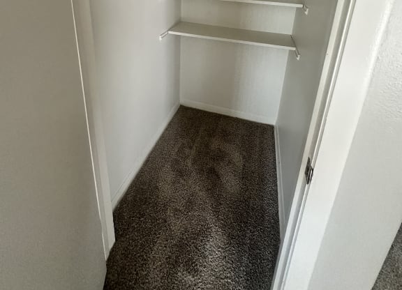 a walk in closet with white shelves and a rail at River Oaks, North Aurora, 60542