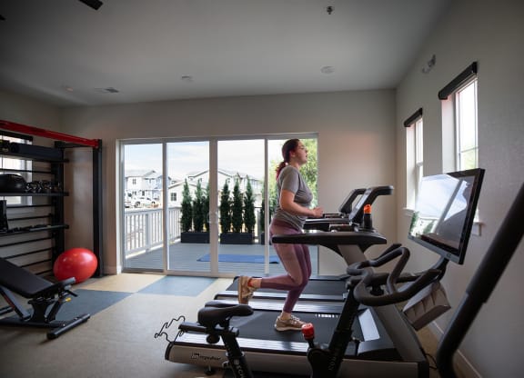 a woman running on a treadmill in a gym