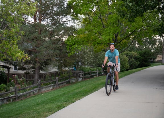 a man riding a bike down a sidewalk