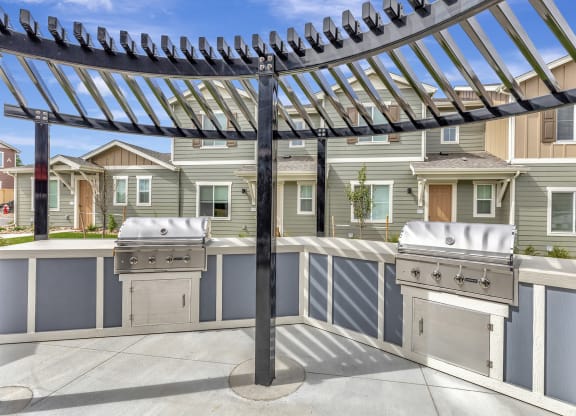 Patio with two grills and a pergola
