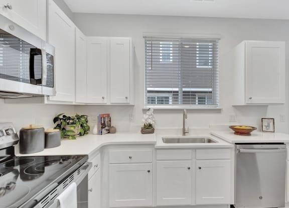 a white kitchen with white cabinets and a sink