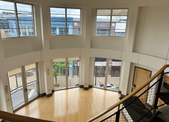 the view from the top of the stairs in a building with large windows