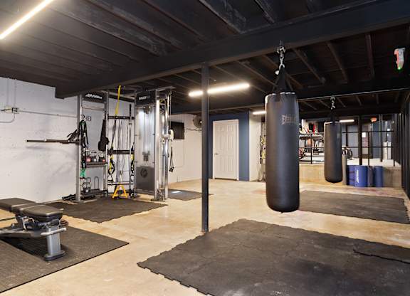 A gym with a punching bag hanging from the ceiling.