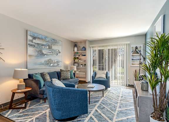 A blue couch is in the middle of a living room.