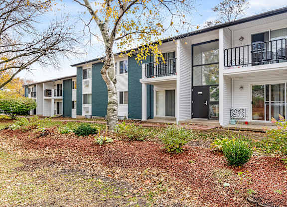 A row of modern townhouses with white and green exteriors.