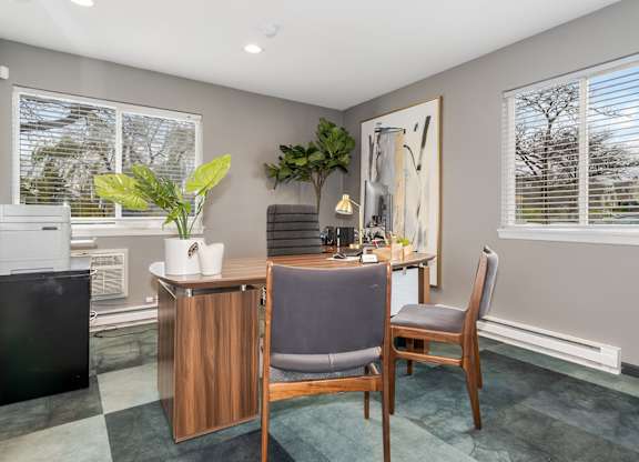 A room with a chair, a table, and a plant.
